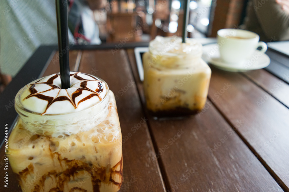 Sticker coffee, iced coffee mocha on table wood background in cafe