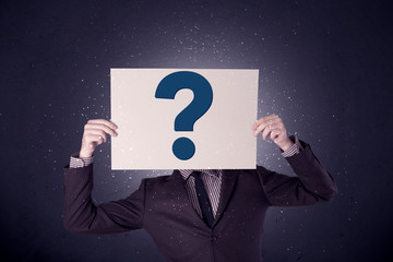 Businessman holding paper with question marks