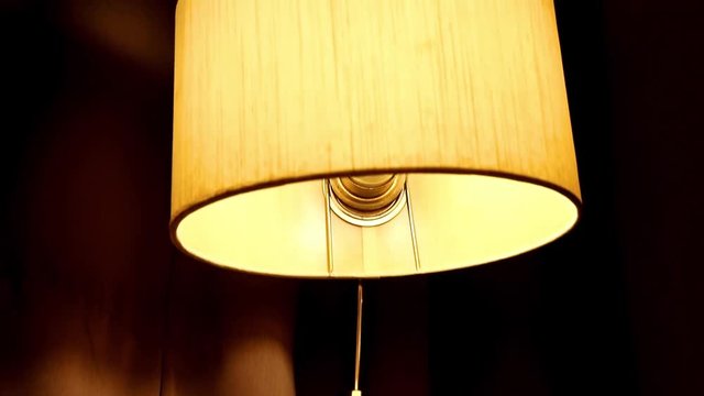 Nostalgic room in the old hotel. The old lamp shining at retro radio. Vintage bedroom with radio and a table lamp above the bed.
