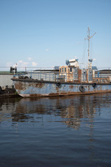 Fototapeta na wymiar An old rusty ship in the pier on the Volga river.