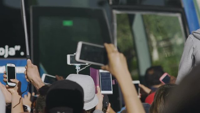 People shooting on smartphones camera leaving of their favorite team, slowmotion