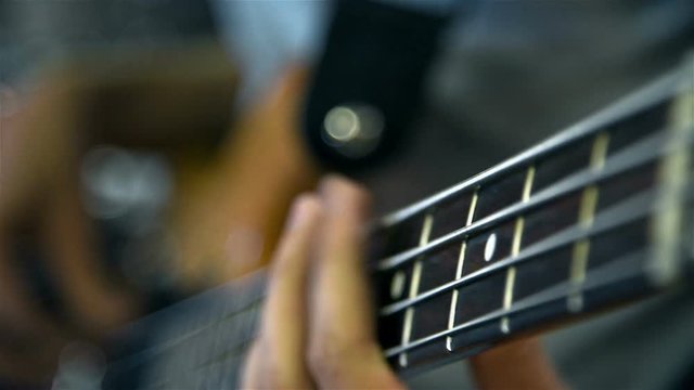 Man Playing On Bass Guitar. Slow Motion Effect