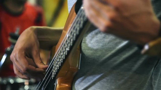 Close Up Of Hands Of Man Playing Electrical Bass Guitar