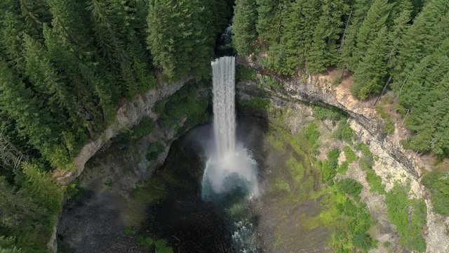 Helicopter Slow Motion View of Tall Waterfall at Massive Crater in British Columbia Canada Wilderness