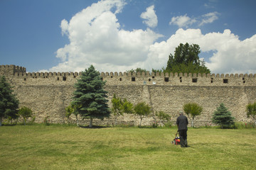 草を刈るおじさんと青空