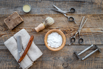 Barber workplace. Shaving brush, razor, foam, sciccors on wooden table background top view