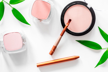 Makeup. Eyeshadow, brush and blush on white table background top view