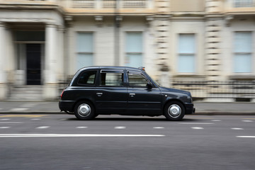 Panning shot of a black taxi in London.