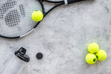 Sport background. Tennis balls and racket on grey background top view copyspace
