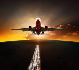 passenger plane take off from airport runway agasint beautiful sun rising sky