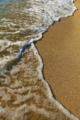 Fototapeta na wymiar Sand on the beach and sea foam