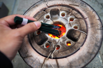 People is lighting incense stick in japanese temple