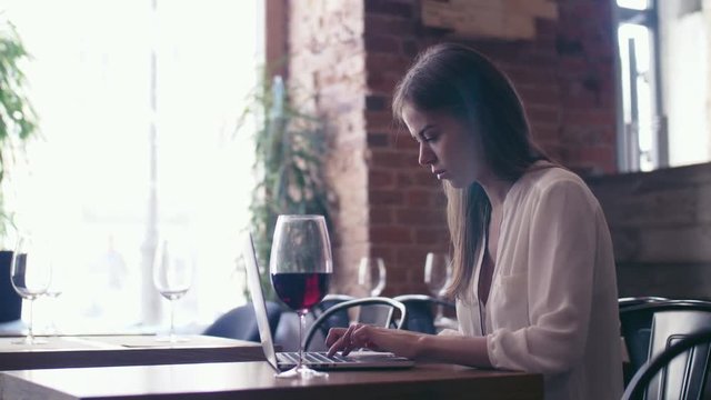 Young girl with laptop in cafe