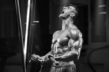 Muscular man working out in gym doing exercise, strong male torso abs