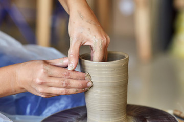 Fototapeta na wymiar Creating jar or vase of clay. Woman hands, potter's wheel