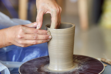 Creating jar or vase of clay. Woman hands, potter's wheel