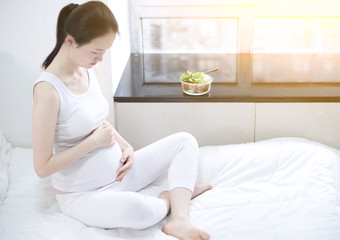 Obraz na płótnie Canvas healthy nutrition and pregnancy. pregnant woman's belly and vegetable salad