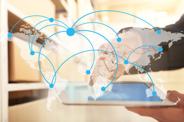 World map with logistic network and man using tablet on background