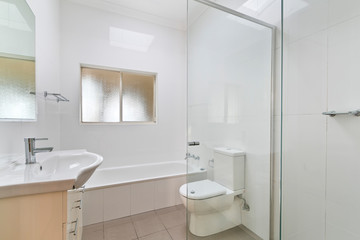 Naklejka na ściany i meble A modern bathroom with a shower area and a bathtub including a wall mirror
