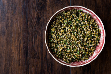 Lentil Salad in ceramic bowl on wooden surface..
