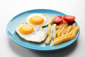 Tasty breakfast with fried eggs on white background