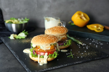 Composition of two tasty burgers on slate plate