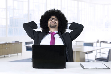 Afro businessman daydreaming in office