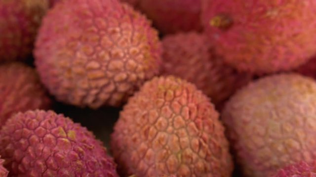 Lychees on a rotating wooden plate (seamless loopable; 4K)