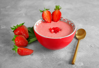 Composition with fresh homemade yogurt and strawberries on grey background