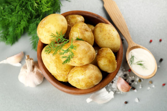 Composition with boiled potatoes, garlic and sour cream on table