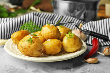 Plate with boiled potatoes on table
