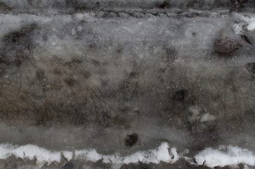 Winter melting snow dark gray background reflection in water