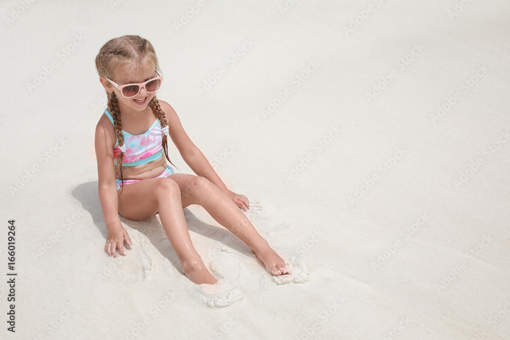 Canvas Prints cute little girl sitting on beach sand at sea resort