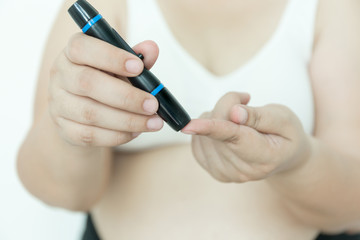 Fat woman with glucometer checking blood sugar level.
