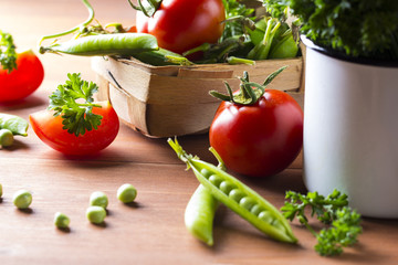 Fresh vegetables Green peas tomatoes dill Wooden background
