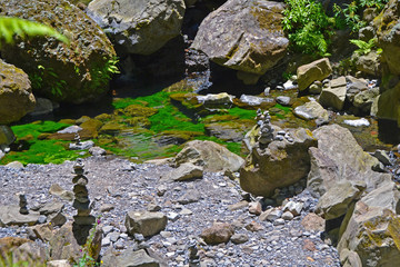 The green water of a mountain river with rocks around.