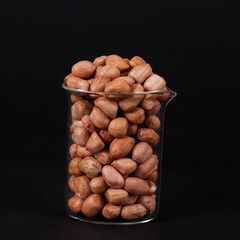 ground nut in glass  on black background