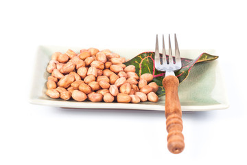 ground nut in green dish with fork  on white background.