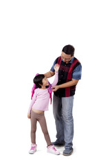 Man helps his daughter to wear bag