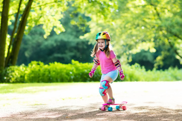 Fototapeta premium Child riding skateboard in summer park