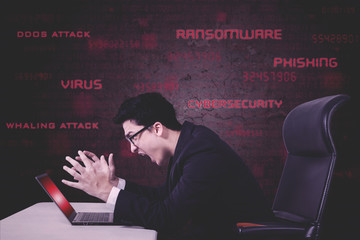 Stressful businessman screams on damaged laptop