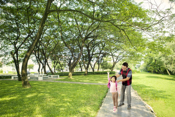 Young father wearing a backpack to her daughter