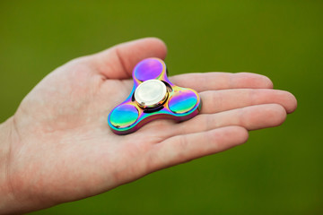 Rainbow hand fidget spinner in the man's hand