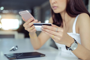 Woman verifies account balance on smartphone with mobile banking application.