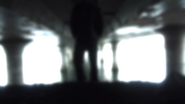 Person walking away through bright light tunnel  with heavenly effect.