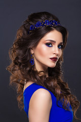 Fashion portrait of a beautiful young woman with a blue jewelry