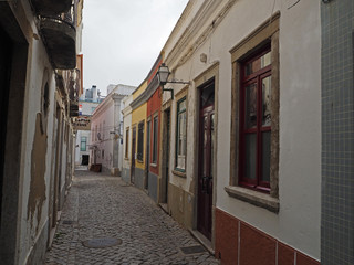 Fototapeta na wymiar small empty street with flaking colour hoses in Naples