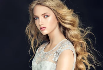 Papier Peint photo Salon de coiffure Blonde fashion  girl with long  and   shiny curly hair .  Beautiful  model  in light blue dress with wavy hairstyle .  