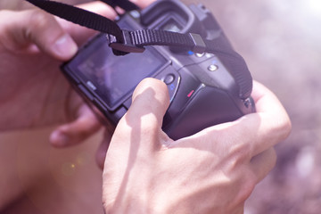 A man examines photos on the camera. Autumn. Summer.
