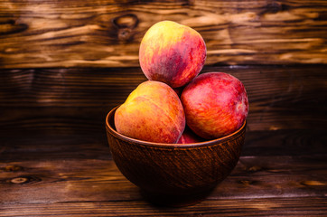 Peaches in a bowl on wooden table